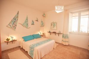 a bedroom with a bed with blue pillows on it at Le Case di Felicita in Santa Teresa Gallura