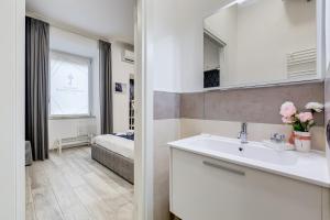 łazienka z umywalką oraz sypialnia z łóżkiem w obiekcie Maison Risorgimento w Rzymie +37 zdjęć