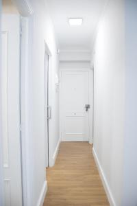 an empty corridor with white walls and a white door at Surf Home, Orzán in A Coruña