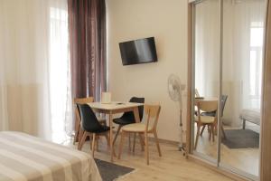 リヴィウにあるApartment in the centre of Lvivのテーブル、椅子、鏡が備わる客室です。