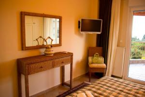 una camera da letto con specchio, letto e televisore di Luxurious Apartment With Sea & Mountain View a Litóchoron