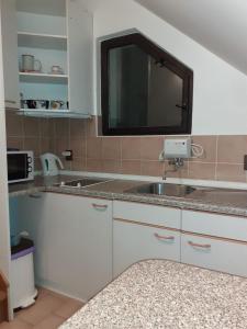a kitchen with a sink and a microwave at Apartmán Schovánek in Harrachov