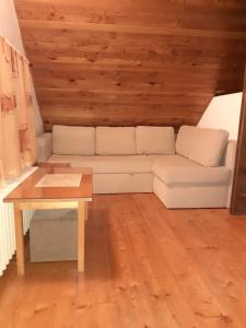 een woonkamer met een witte bank en een tafel bij Apartmán Schovánek in Harrachov