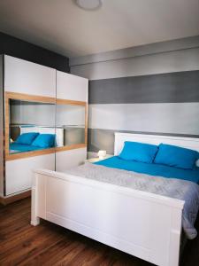 a bedroom with a large white bed with blue pillows at Mia apartment in Bar