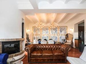 a living room with a leather couch and a fireplace at Belleview Villa in Barcelona