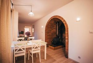 a dining room with a white table and a brick archway at Latron 98 in Český Krumlov