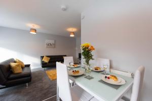 a dining room and living room with a white table and chairs at PREMIER - Wishaw En-Suite Apartment in Wishaw