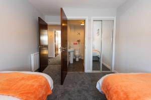 a hotel room with two beds and a mirror at PREMIER - Wishaw En-Suite Apartment in Wishaw