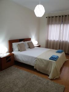 a bedroom with a large bed with two blue towels on it at Heart of Vieira Do Minho - T2 Apartment in Vieira do Minho +20 photos