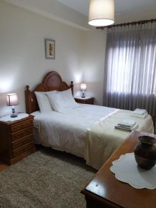 a bedroom with a bed and a table with two lamps at Heart of Vieira Do Minho - T2 Apartment in Vieira do Minho