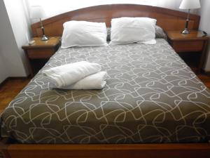 ein Schlafzimmer mit einem Bett mit zwei Kissen darauf in der Unterkunft Studio Suipacha in Buenos Aires