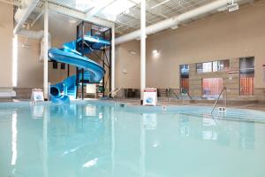 a indoor swimming pool with a blue water slide at Mountain Fun - With Open Pool And Hot Tub in Canmore