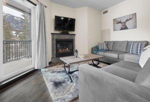 a living room with a couch and a fireplace at Mountain Fun - With Open Pool And Hot Tub in Canmore