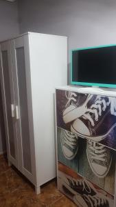 una habitación con TV y zapatos en un estante en LAS MARGARITAS, en Gijón