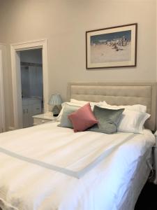 a bedroom with a large white bed with pillows at Fairbank House in Maldon