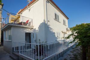 a white apartment building with a balcony and a balcony at Guest House Kušeta in Split