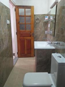 a bathroom with a toilet and a sink and a door at Old Town Hotel in Kandy