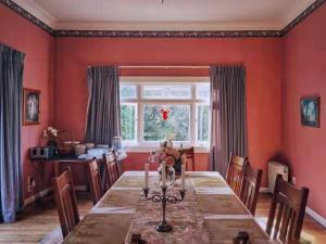 comedor con mesa y ventana en English Cherry Tree Manor, en Tamahere