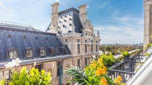einen Balkon mit Blick auf ein Gebäude in der Unterkunft Prestige sur Louvre et Tuileries in Paris