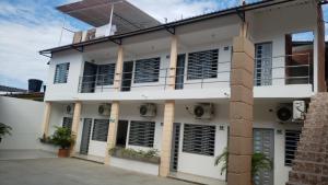 un edificio blanco con ventanas de contraventanas negras en Palmari Hotel, en Purificación