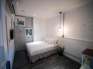 a bedroom with a white bed and a pendant light at King Wow Inn in Tainan