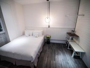 a bedroom with a large white bed and a desk at King Wow Inn in Tainan