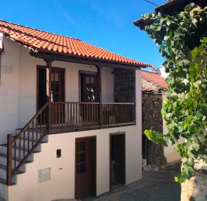 a house with a balcony and a staircase at Studio Rural in Vilarinho