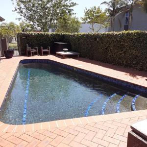 ein kleiner Pool mit blauem Wasser im Hof in der Unterkunft Quantum Lodge Motor Inn in Hamilton