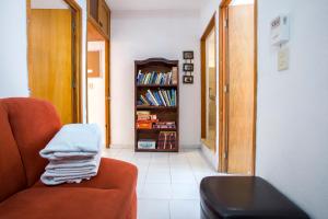 Una sala de estar con una silla y una estantería. en Casa Nona Azul, en Cancún