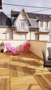 ベルク・シュル・メールにあるLES FRUITS DE MER, terrasse plein sudの- ウッドフロアのバルコニー(ピンクの椅子付)