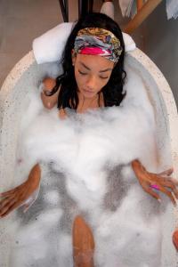 a little girl sitting in a bath tub filled with foam at Jungle Bay Dominica in Soufrière