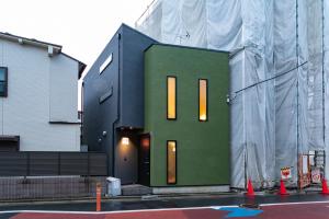 a building is being constructed with a green front at Sakura Stay Keikyukamata in Tokyo