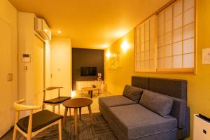 a living room with a couch and a table at Sakura Stay Keikyukamata in Tokyo