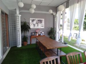 - une salle à manger avec une table et des chaises en bois dans l'établissement The Sofea Inn Transit Room Airport Kota Bharu, à Pengkalan Cepa