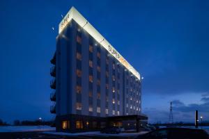 a hotel building with a sign on top of it at Super Hotel Ishikari in Ishikari