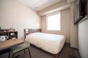 Ishikariにあるスーパーホテル石狩のベッドルーム1室(ベッド1台、デスク、窓付)