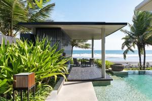 een huis met een zwembad naast het strand bij Soori Bali in Tabanan