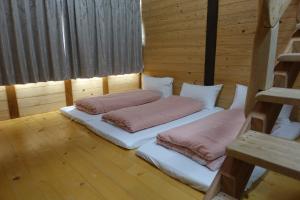 two beds in a room with wooden walls and wood floors at Bixilian B&B in Chenggong