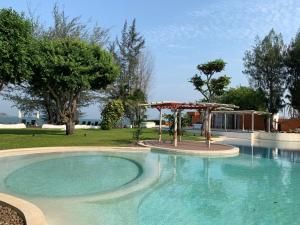 a swimming pool with a gazebo in a yard at Mexican Beachfront Condo in Khao Tao