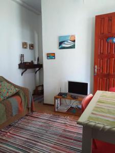 a living room with a couch and a television at Secret Recreio in Rio de Janeiro