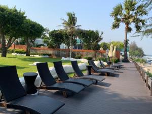 考濤海灘的住宿－墨西哥海濱公寓，棕榈树甲板上的一排躺椅