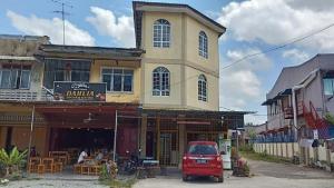 a red car parked in front of a building at Homestay Taman Maktab Pengkalan Chepa in Pengkalan Cepa