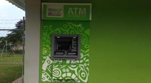 an atm machine on the side of a green wall at Mountain Panoramic View in Isaka