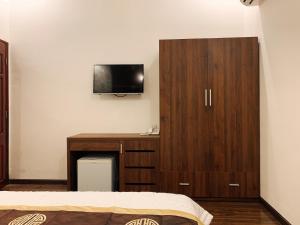 una camera da letto con armadio in legno e TV a parete di AN NGỌC HOTEL a Can Tho