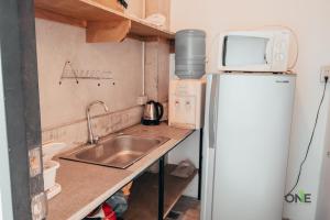 a small kitchen with a sink and a refrigerator at One Biñan Place in Biñan