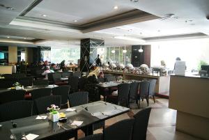 a restaurant with tables and chairs and people in the background at Tang Dynasty Hotel in Kota Kinabalu