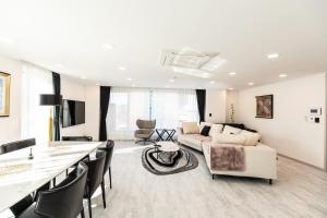 ein weißes Wohnzimmer mit einem Sofa und einem Tisch in der Unterkunft La vie est Belle in Incheon