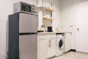 een keuken met een koelkast en een wasmachine bij S2 Silom Large room 4-6 guests Full kitchen WIFI in Bangkok