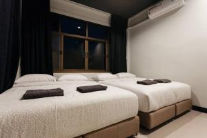 2 camas en un dormitorio con ventana en S3 Silom26 · S3 Silom central, large room, full kitchen, WIFI,, en Bangkok