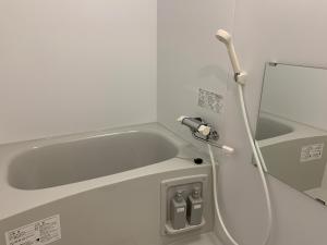 UCHI Susukino 5.7 في سابورو: حوض استحمام في غرفة مستشفى مع خرطوم مياه